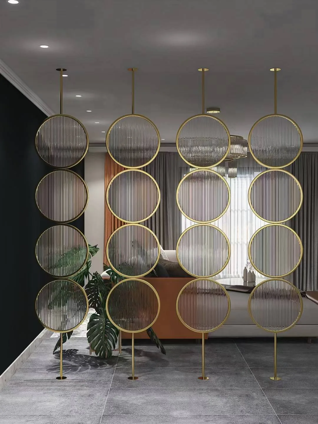 Floor-to-ceiling circular gold-tone metal divider with fluted glass inserts