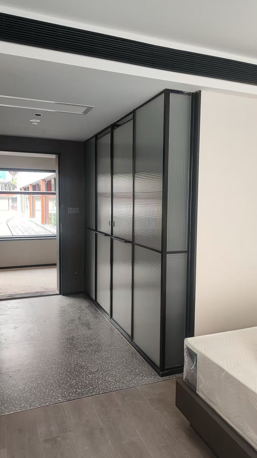 Black metal framework with fluted glass panels in a contemporary interior partition