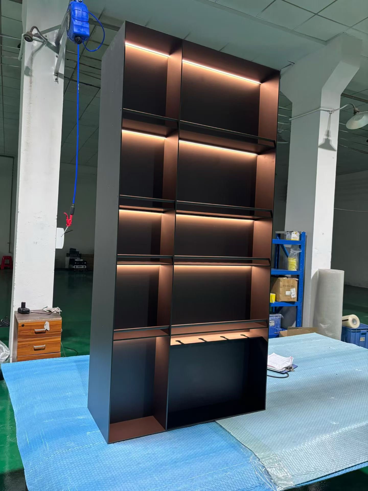 Tall bronze finished retail shelving unit with integrated warm lighting