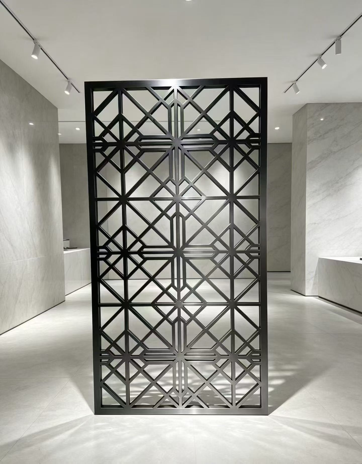 Black geometric custom metal screen installed in a minimalist interior