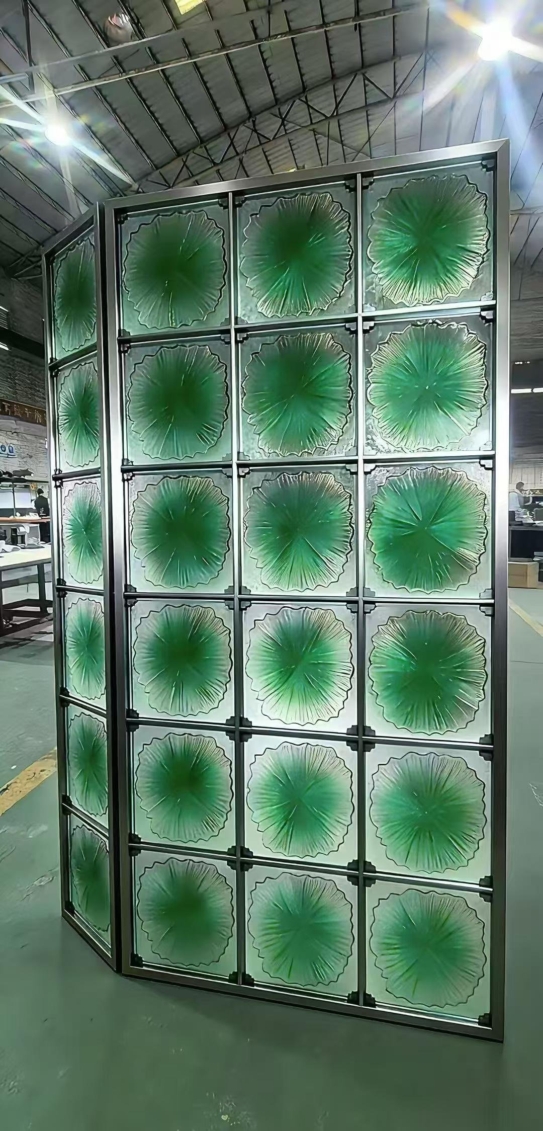 Freestanding metal screen assembled with translucent green decorative glass panels