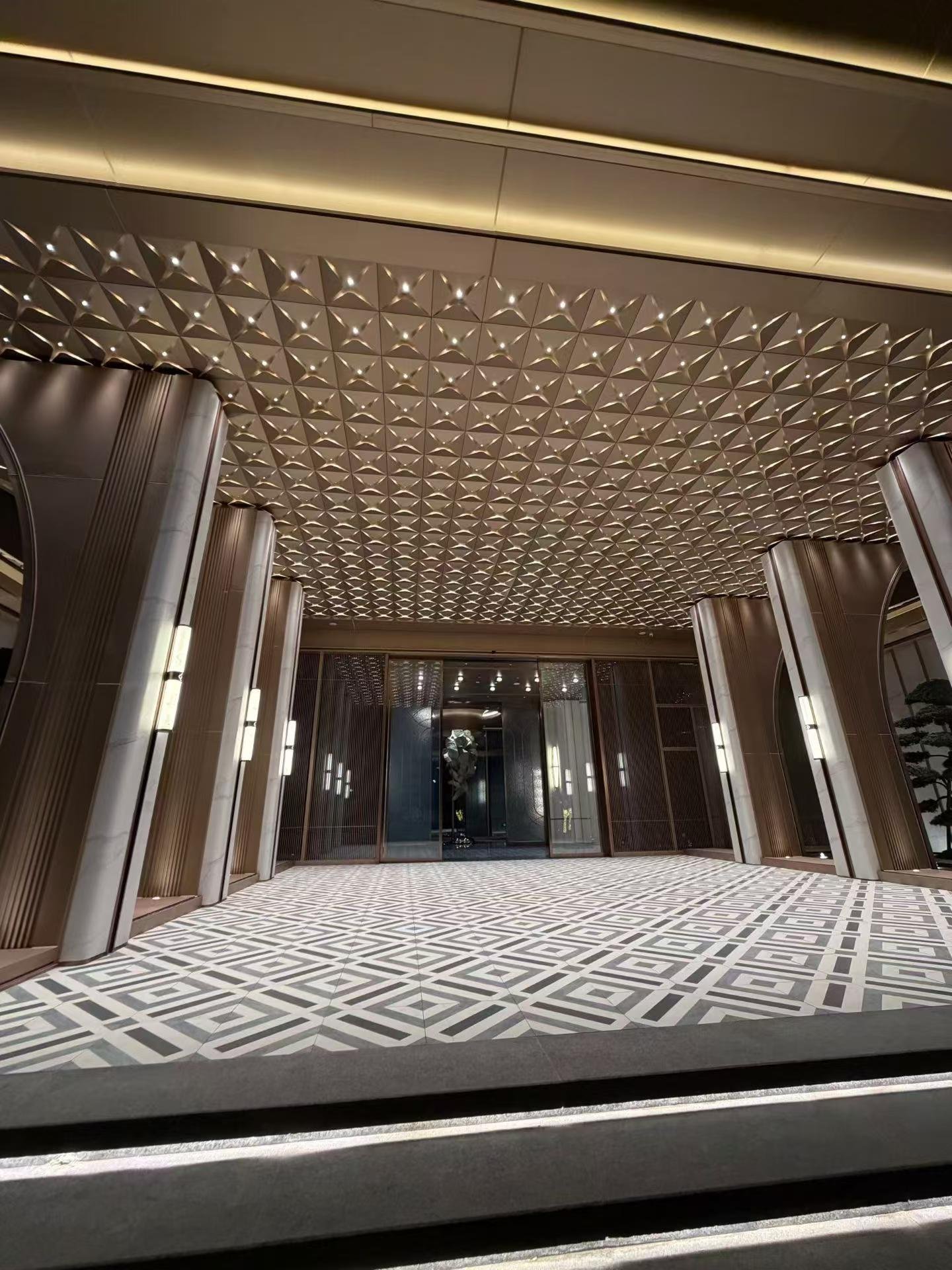 Completed commercial entrance with a sculpted metallic ceiling installation